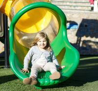 Child sliding down a playground tube slide at Chandragiri Amusement Park