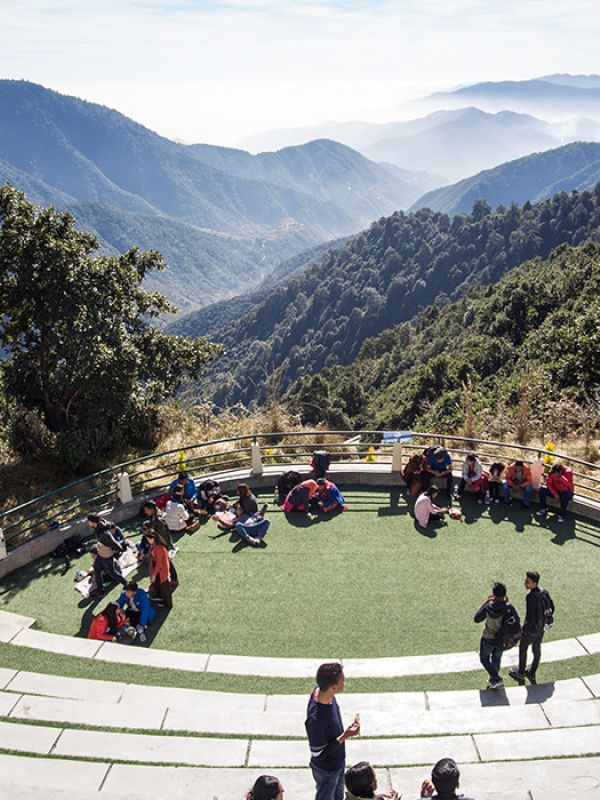Visitors relaxing at the open-air amphitheater in Chandragiri Hills with panoramic views